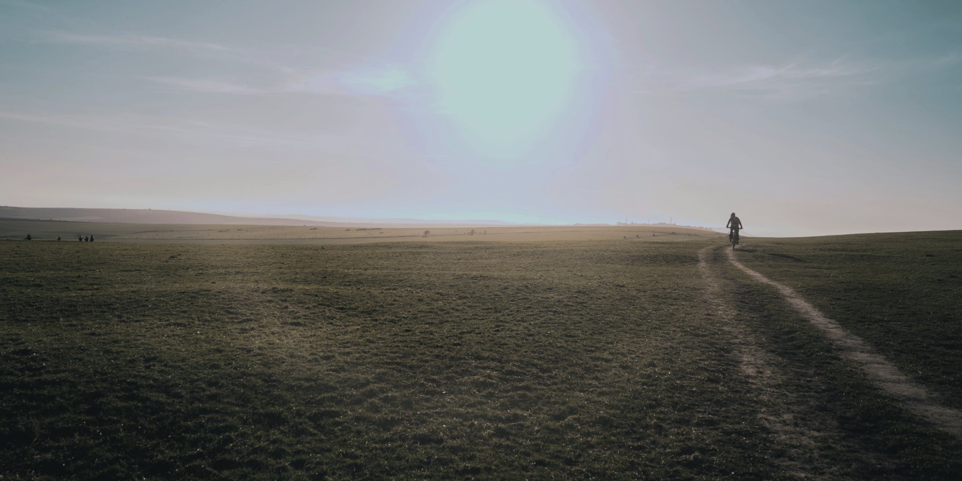 Cyclist on open trail at sunrise