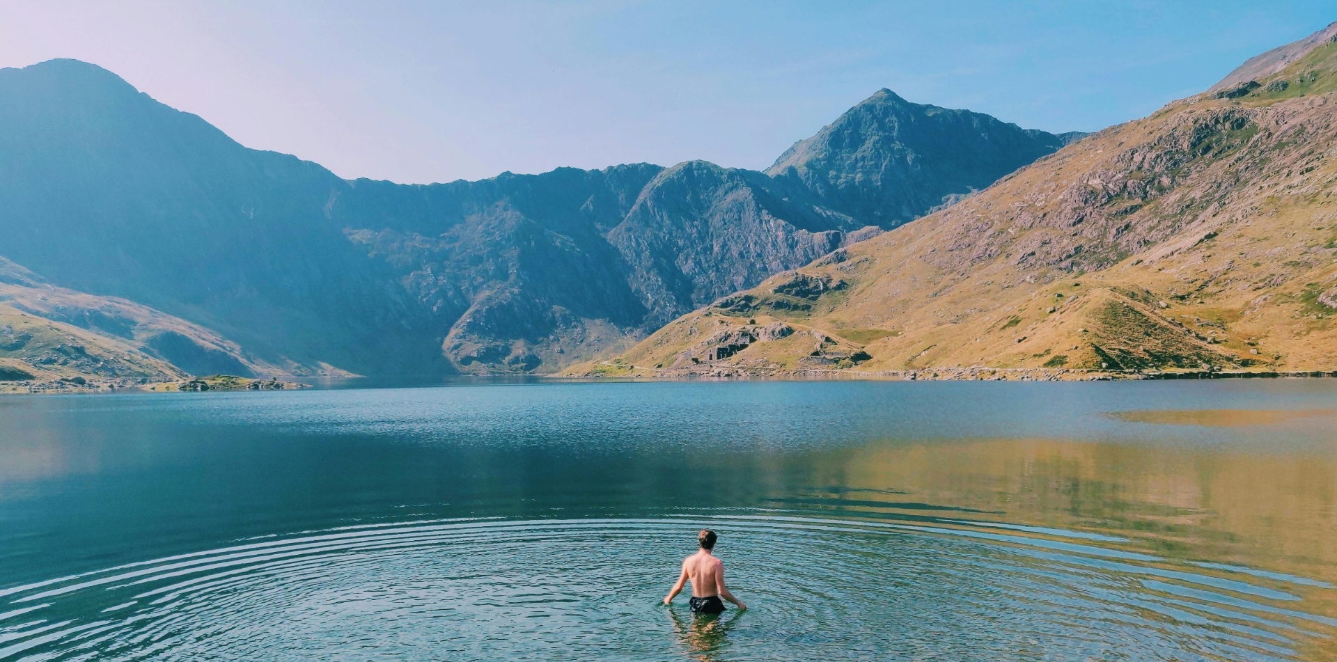 Person wild swimming in mountain lake